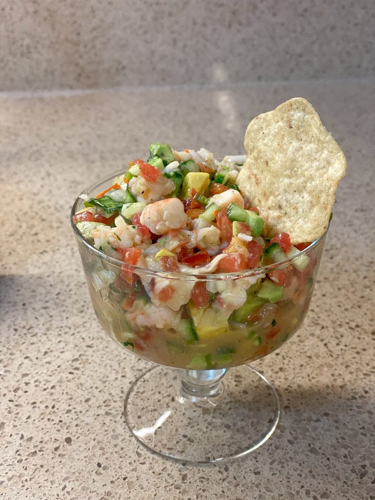 ceviche in a glass bowl with a tortilla chip in it
