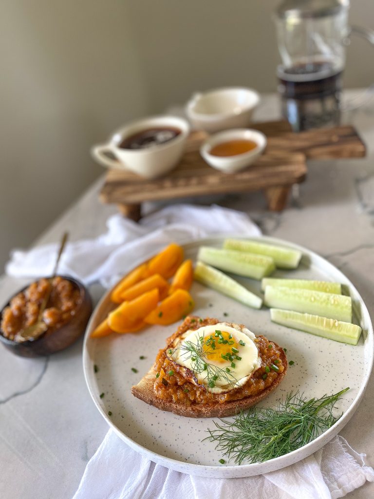 breakfast plate with zucchini spread on a toast with an egg on top