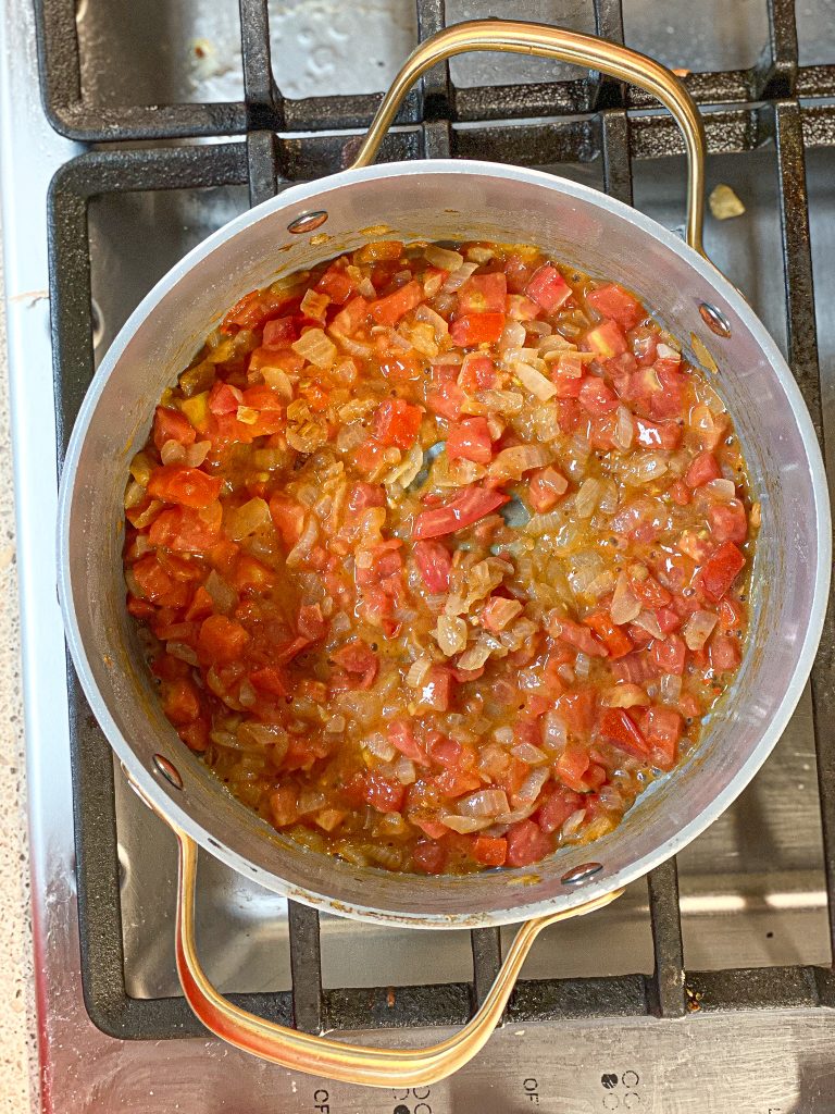 onion and tomato cooking in a pot on the stove