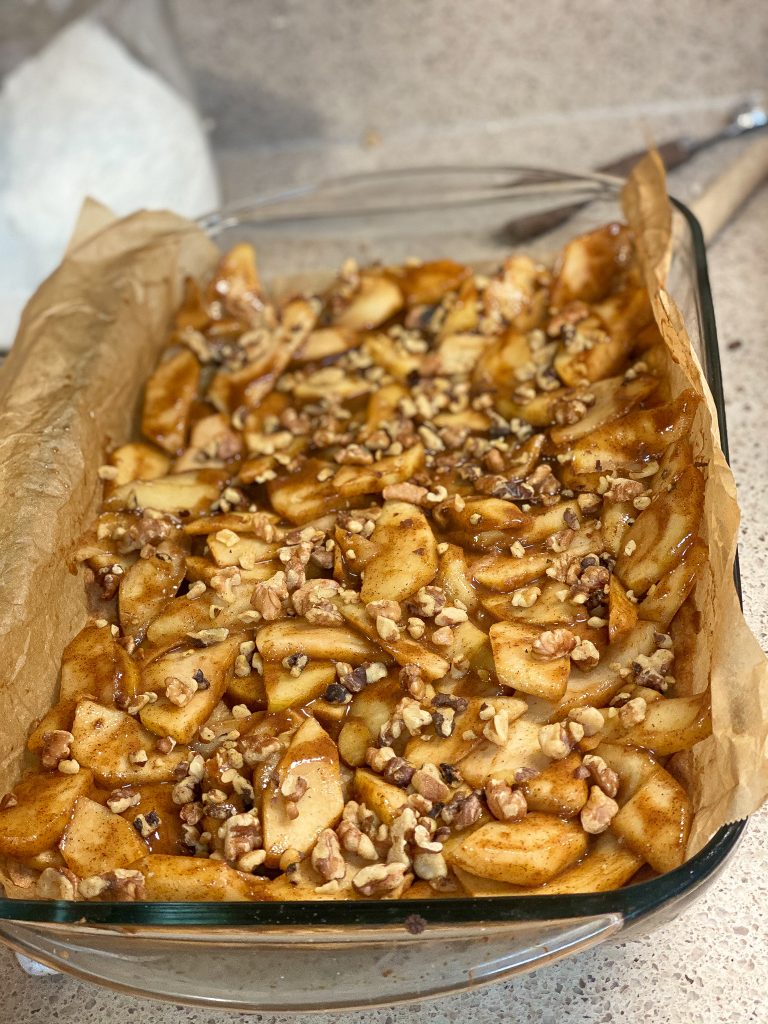 apple slices in a baking sheet with walnuts on top
