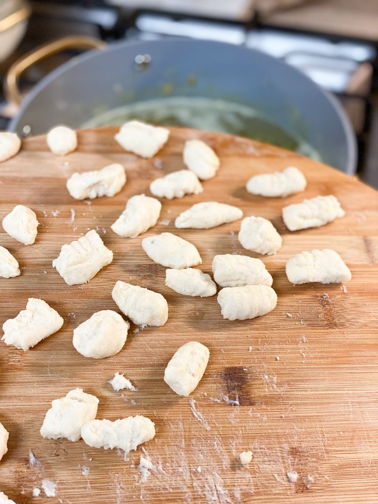 gnocchi on a wooden board on top of a pot