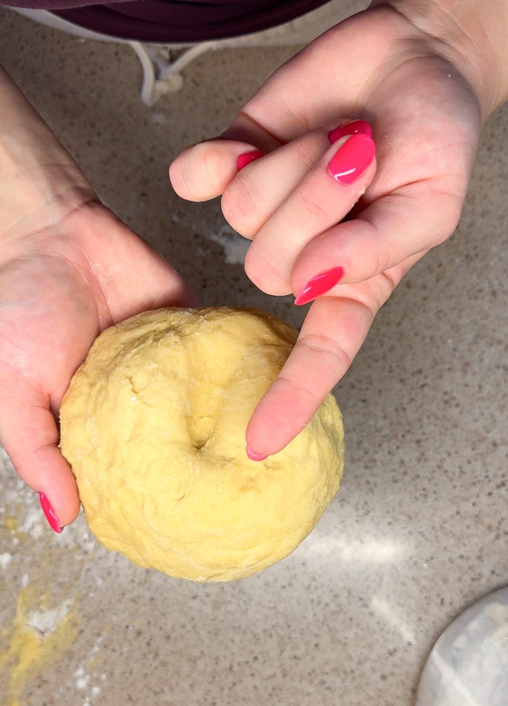 hands holding a ball of pasta dough 