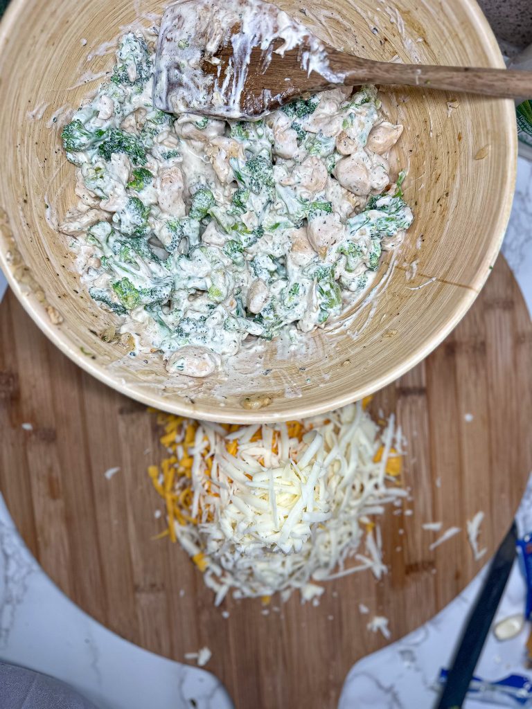 creamy ranch chicken with broccoli mixture in a wooden bowl with shredded cheese
