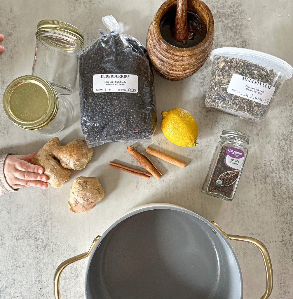 ingredients laid out on a table to make Homemade elderberry syrup (a super cough suppressant)