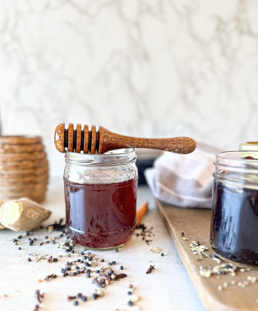 hot elderberry tea with mullein leaf with a honey spoon over the jar