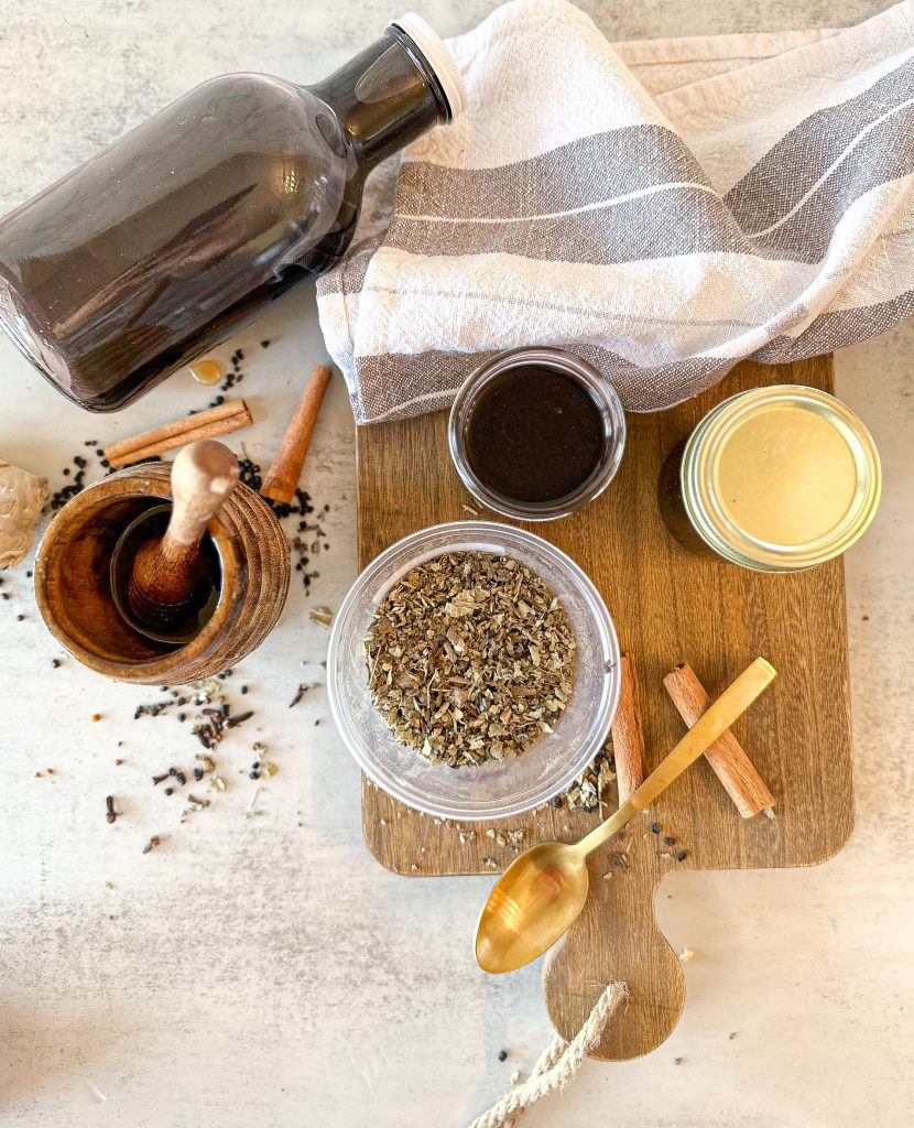 Homemade elderberry syrup (a super cough suppressant) in jars on a wooden board 