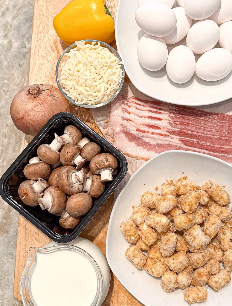 ingredients laid out on a wooden cutting block to make Bacon And Egg Tater Tot Breakfast Casserole 