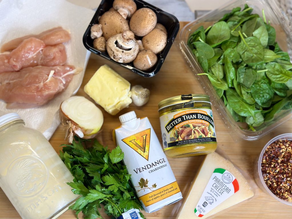 ingredients laid on a wooden countertop to make creamy chicken orzo