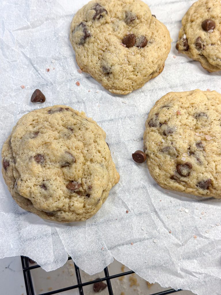 sourdough discard chocolate chip cookies on parchment paper cooling on a cooling rack