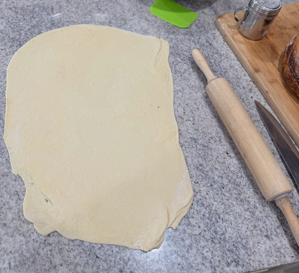Rolled-out enriched sourdough dough on a countertop, ready for spreading the poppy seed filling