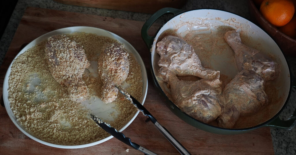 Breadcrumb coating: Marinated chicken drumsticks being coated in Italian-style breadcrumbs before cooking in the air fryer.